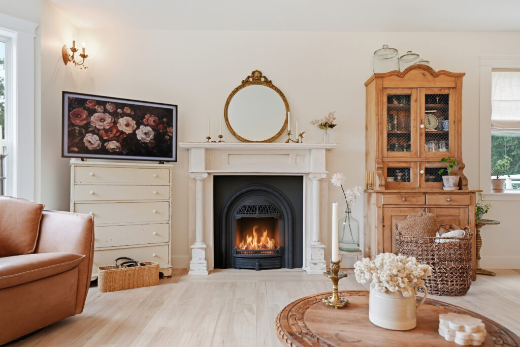 A living room shows a fireplace, cupboards, and decorative elements like flowers.